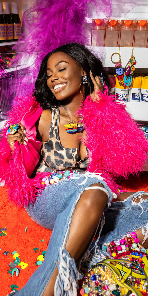 Black girl in pink fur jacket with hoop earrings on. 